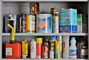 Picture of a shelf with household hazardous waste on it, including paint, pesticides, bleach, gasoli