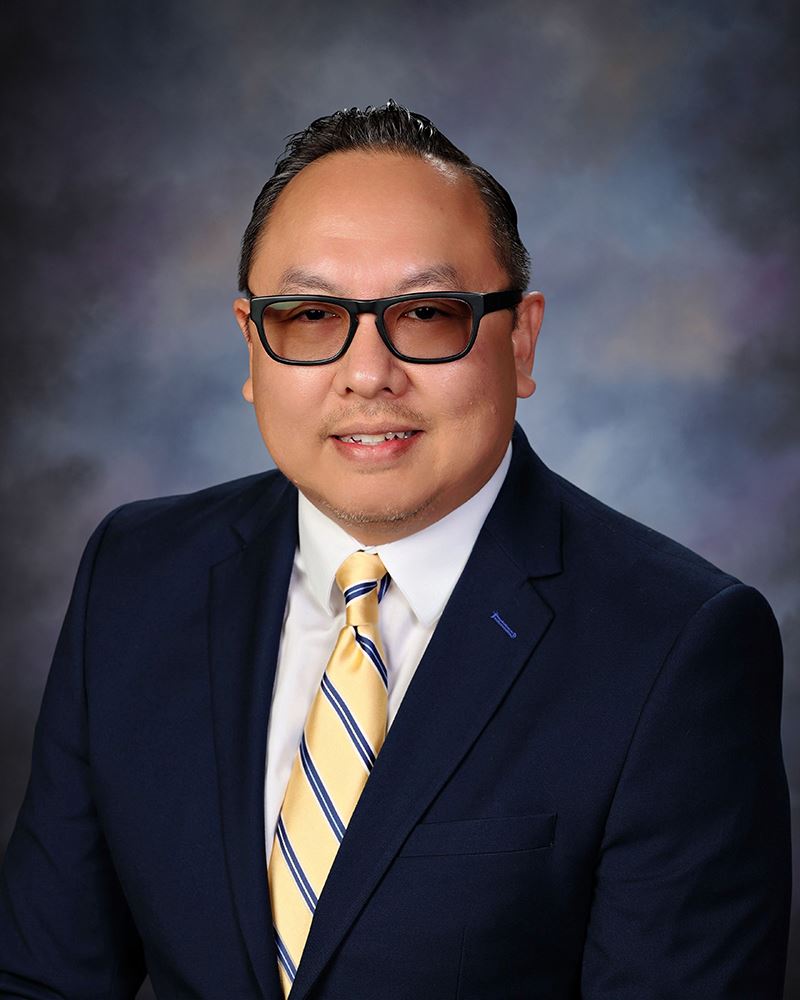 Smiling PJ Gagajena with palm tree behind him